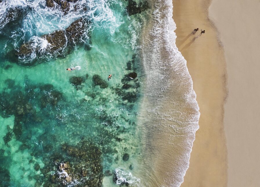 aerial view two people walking secluded cabo san lucas shore