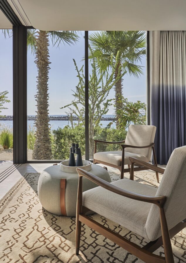 Sitting corner of Los Cabos luxury villa with modern chairs, large pouf and binoculars for whale watching.