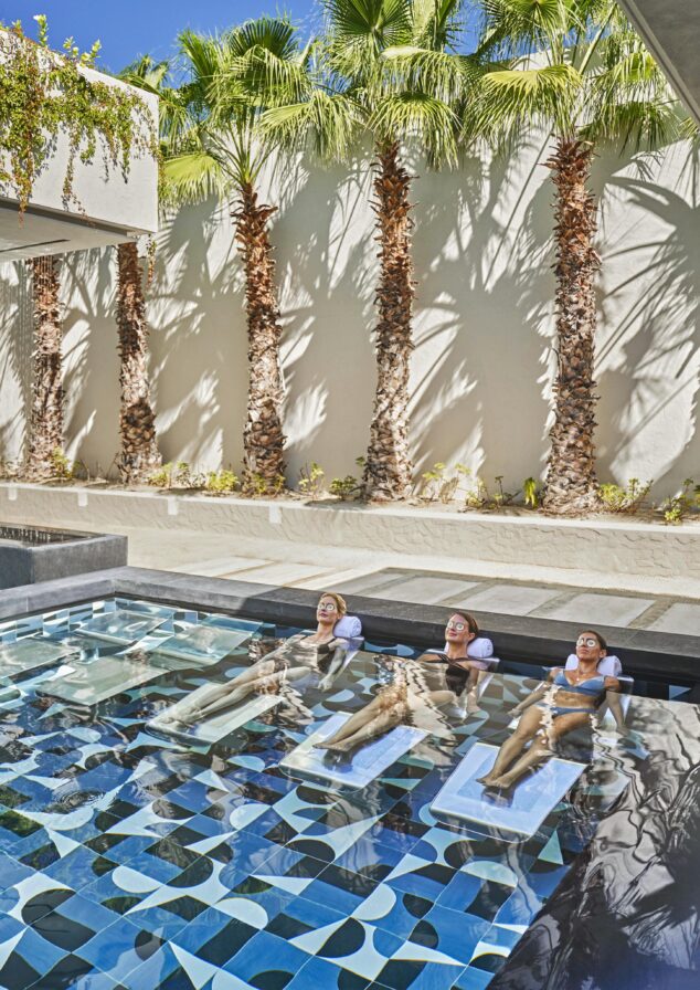 Three women lounging and submerged in luxury spa and pool at Four Seasons Los Cabos at Costa Palmas resort.
