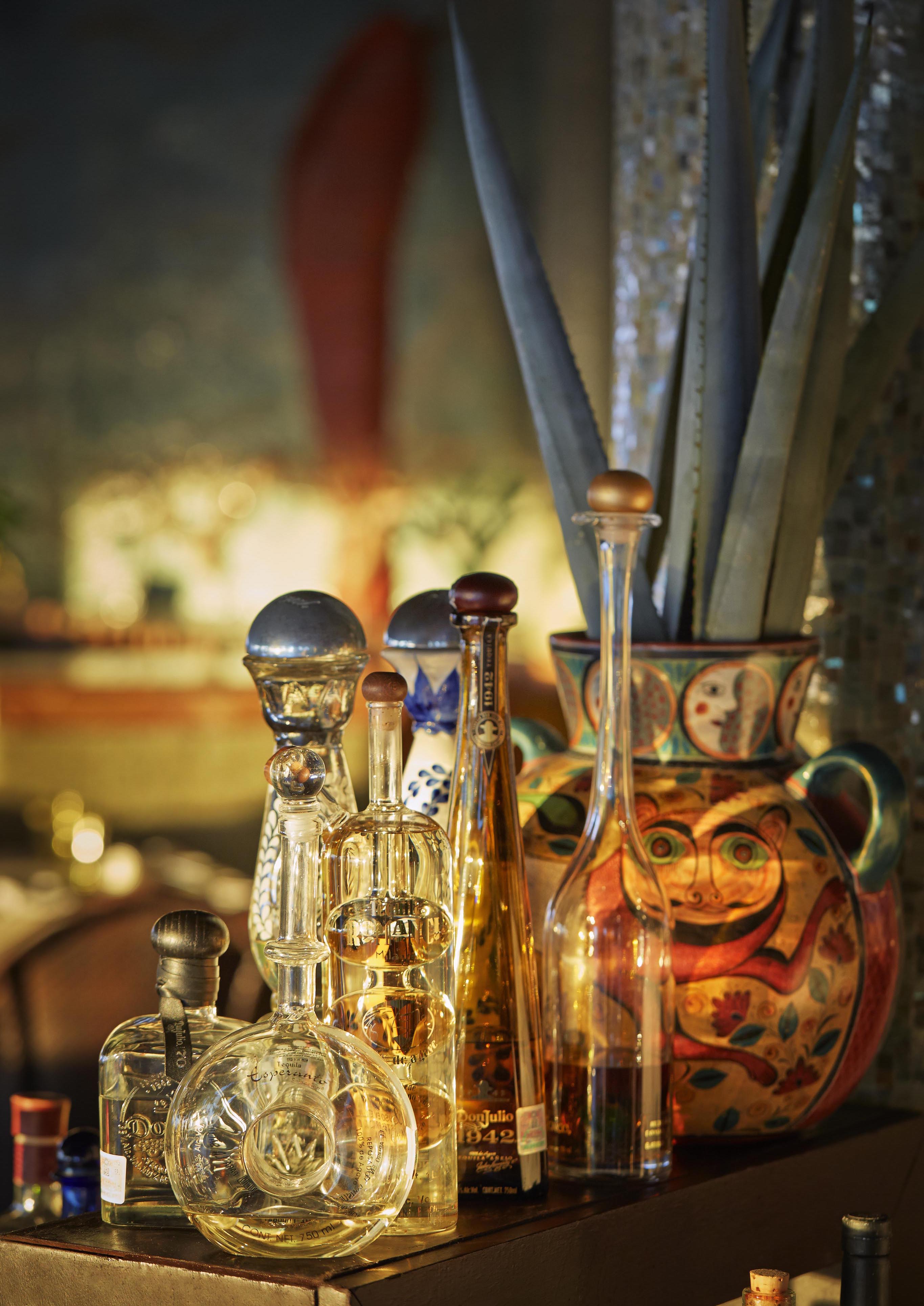 Brightly colored uniquely shaped curved glass bottles at Four Seasons Punta Mita tequila tasting.