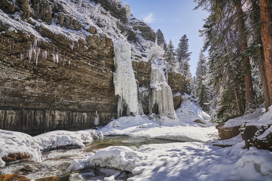 Large Montana rock face, snow covered gallatin river frozen waterfall