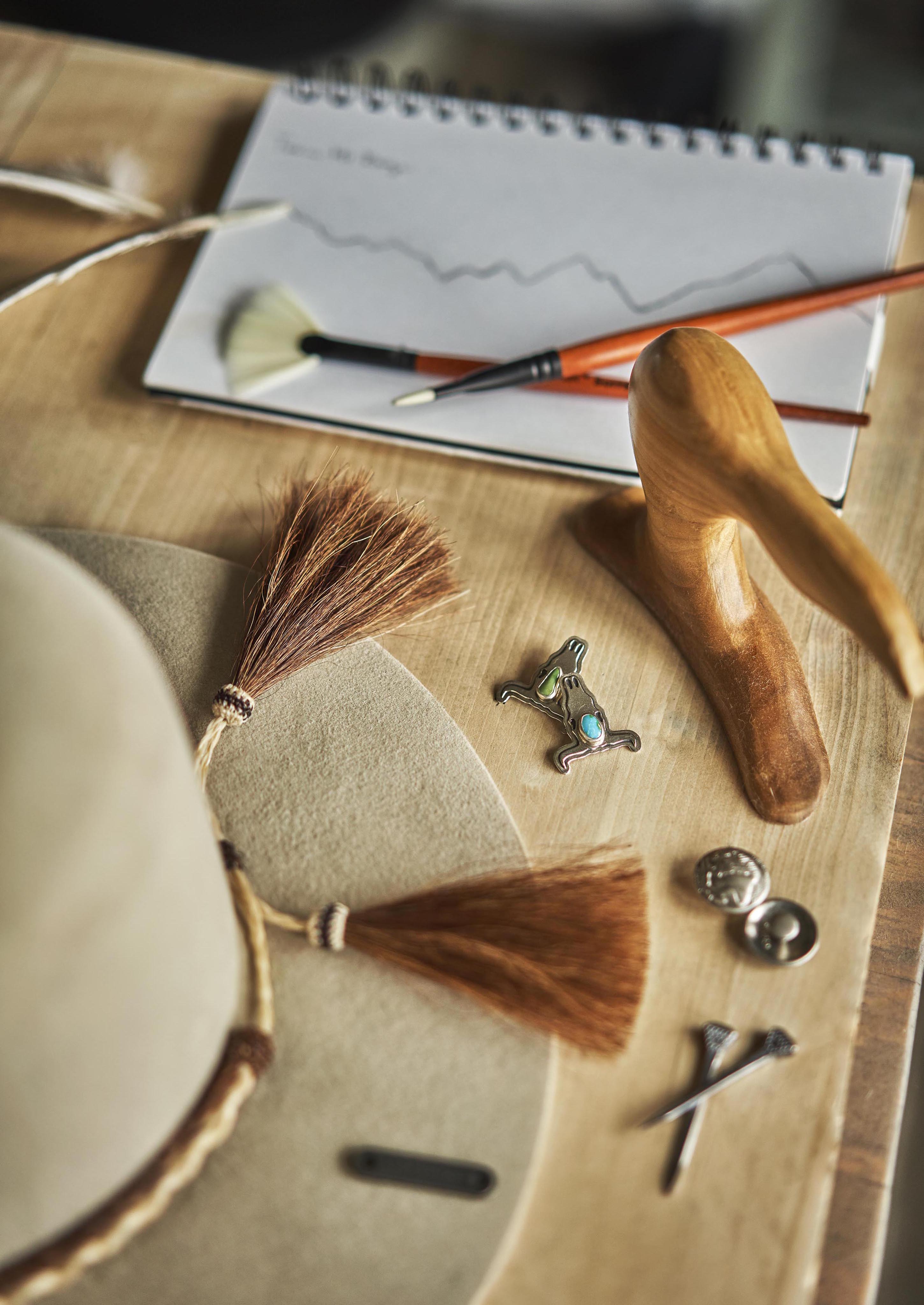 Details of hat making tools, paint brush, displayed on wood table of local Montana hat maker.