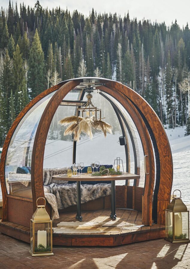 Exclusive outdoor deck dining area nestled in luxury Montage Deer Valley mountain ski resort surrounded by pine trees