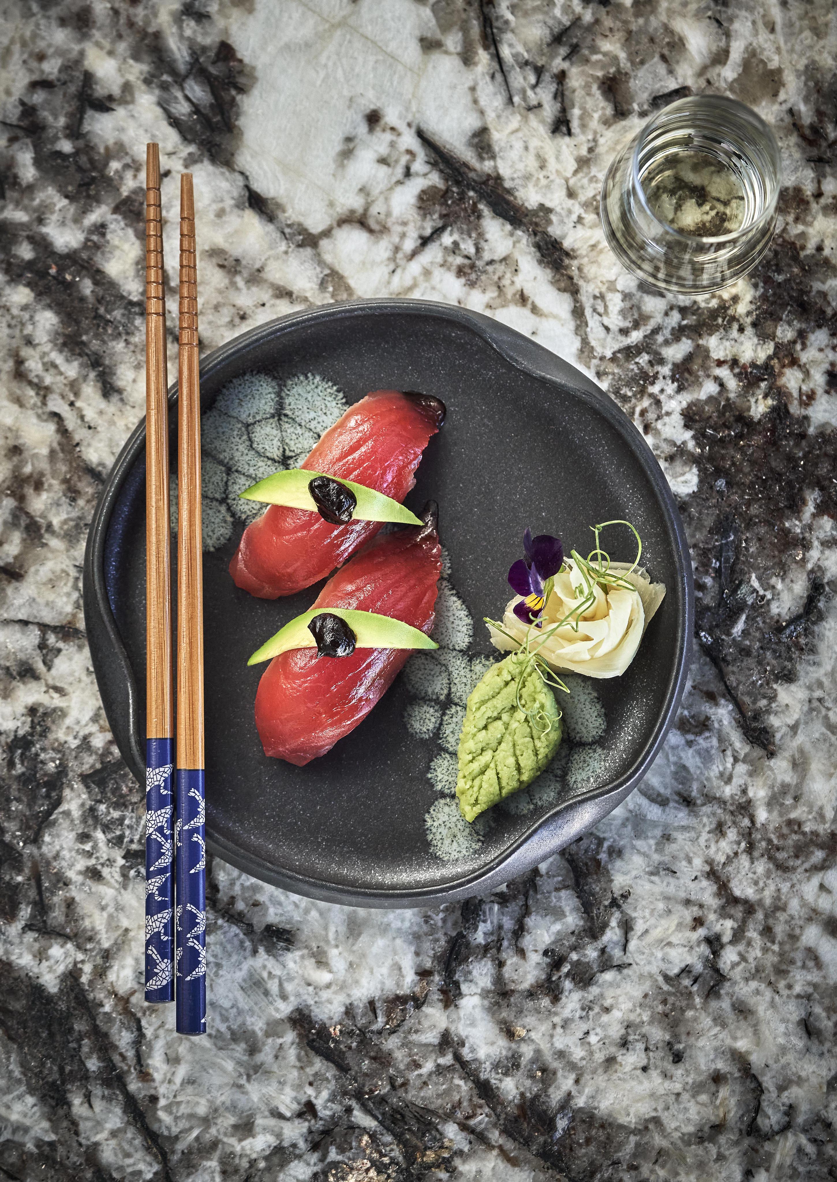 Top down view of ornate sashimi sushi tuna dish served on black and white marble countertop at Montage Los Cabos resort fine dining restaurant Marea.